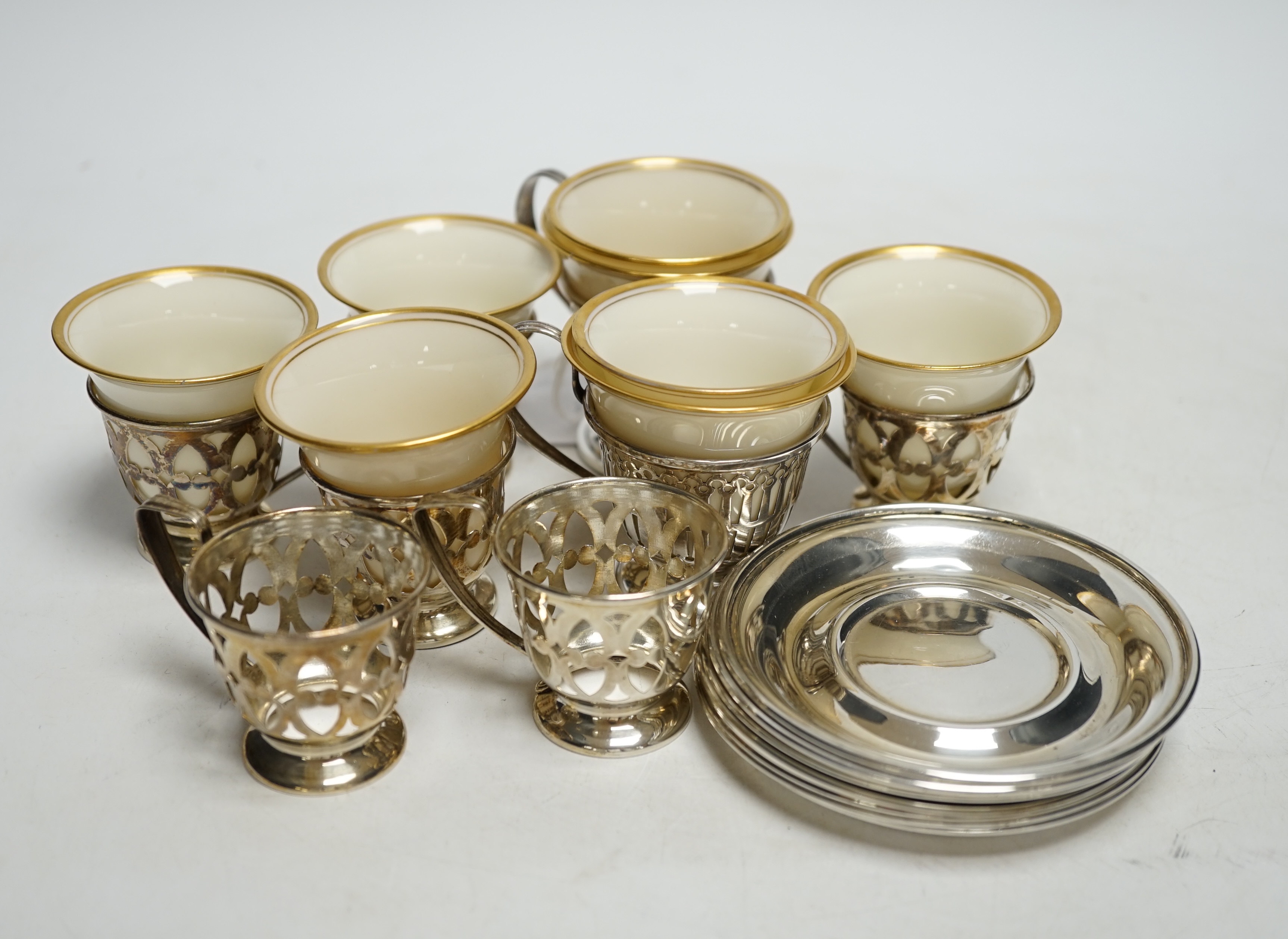 A set of six Limoges Lenox coffee cups with sterling holders and saucers and a pair of larger similar cups with holders and saucers.